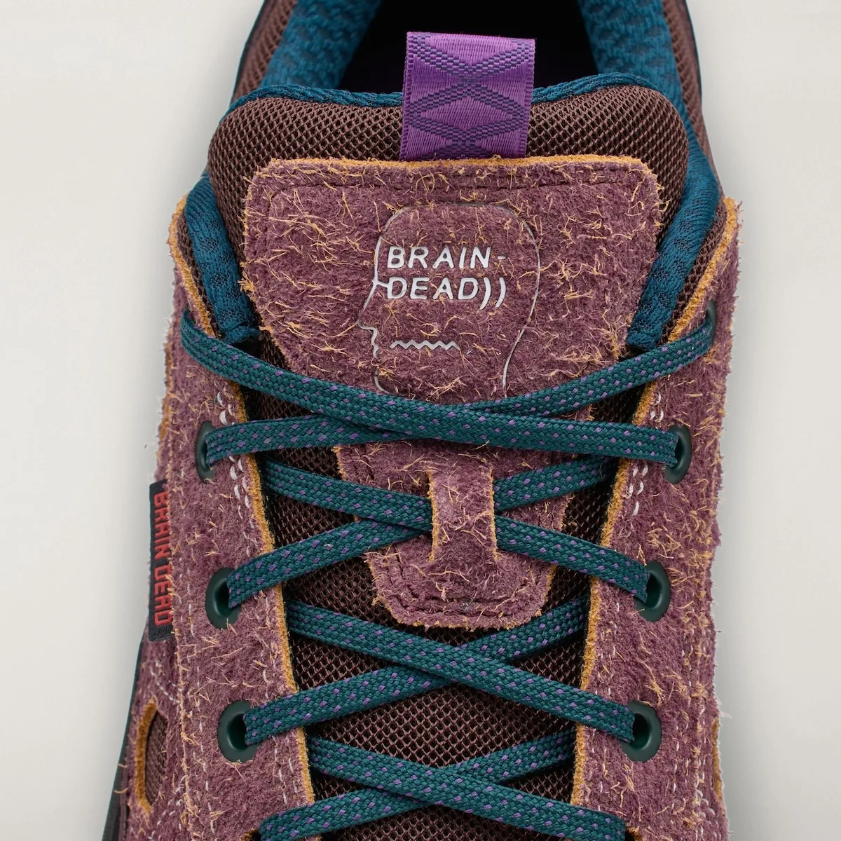close-up of tongue on mauve approach shoe with Brain Dead face graphic, Approach and Niad