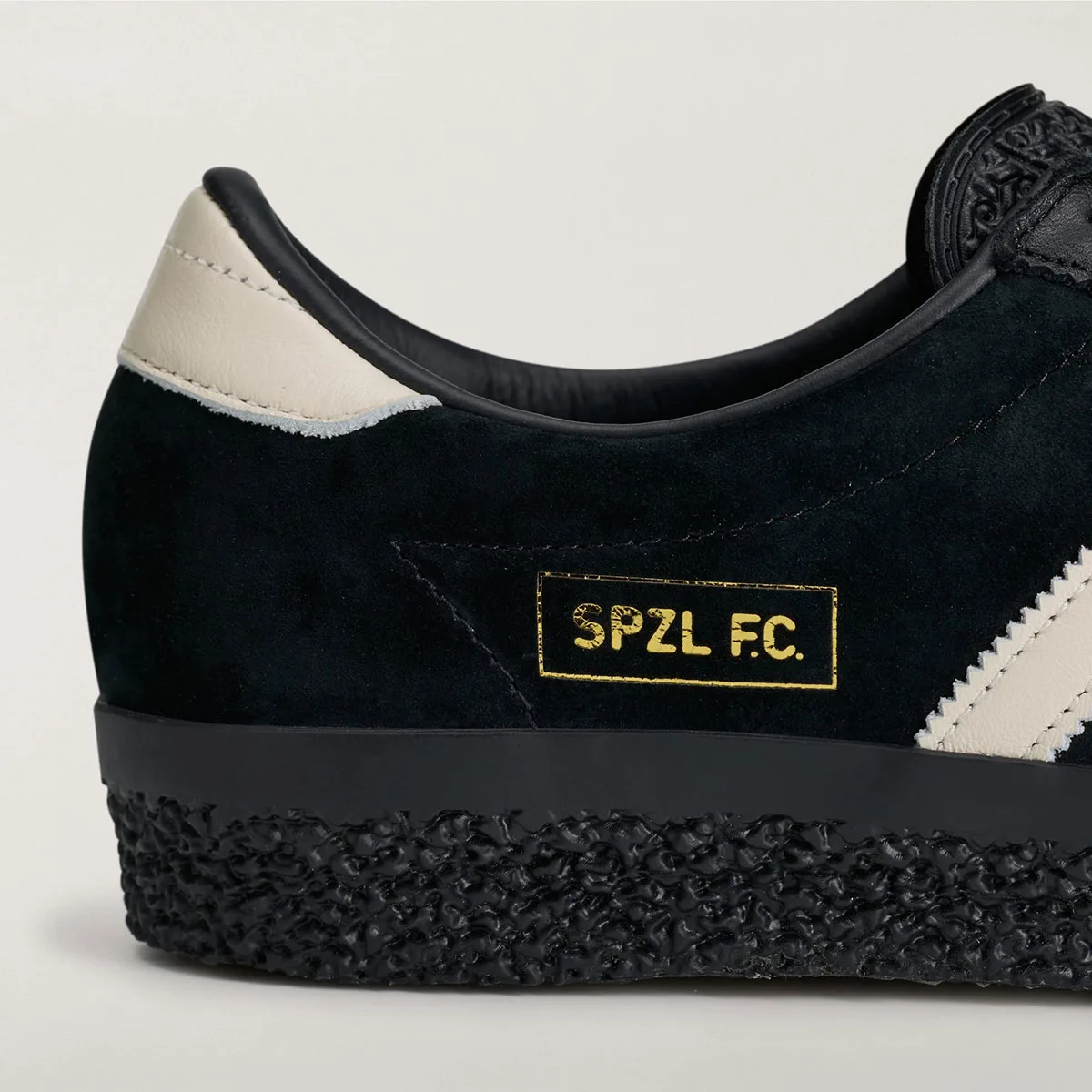 close-up heel detail, gold-foil SPZL F.C. patch on black suede with cream tab, Gazelle SPZL FC
