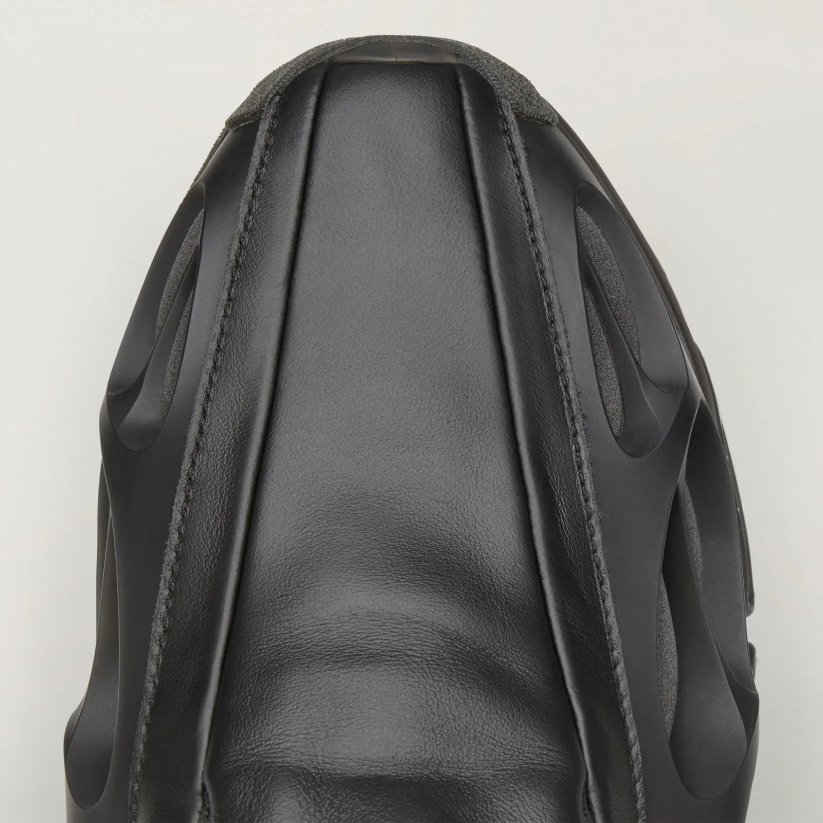 close-up of toe box, black leather seams over vented cage sole, Wolf