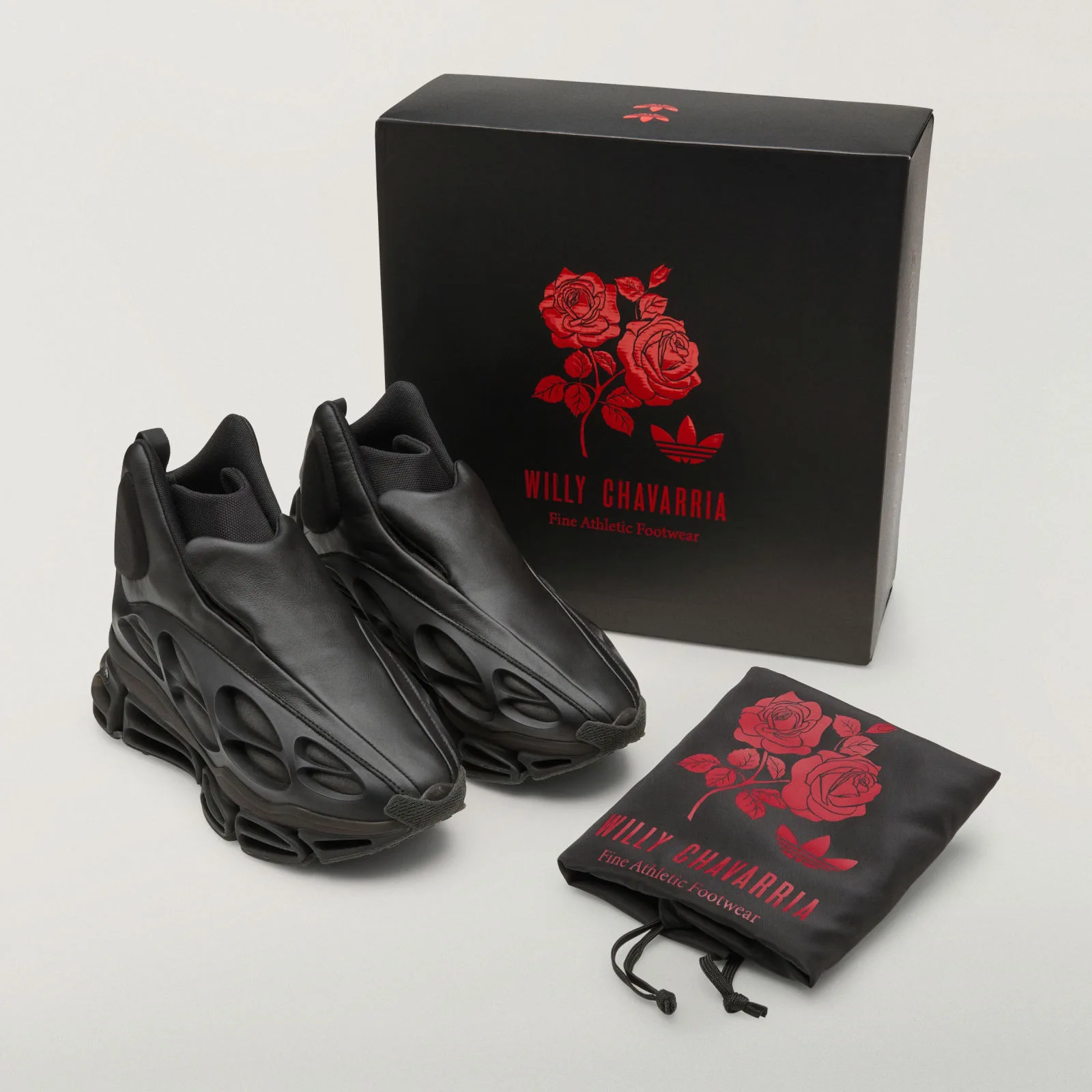 pair beside black box and rose-print dust bag, red rose and logo graphics, Willy Chavarria x adidas Megaride Mid “Wolf”