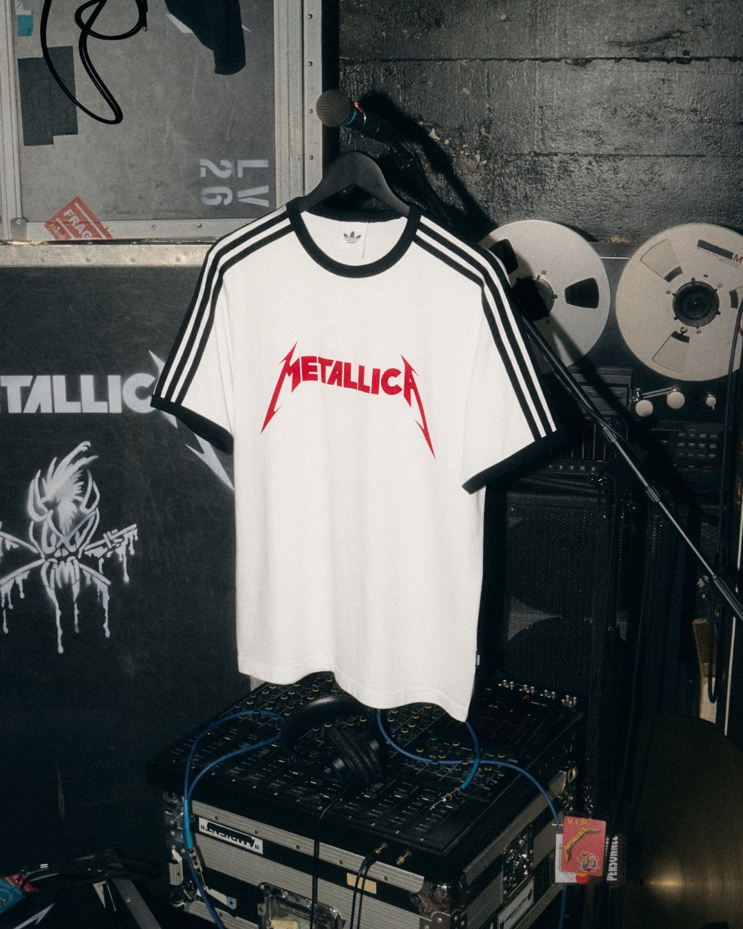 white ringer tee with black stripes and red Metallica logo, tape reels behind, Life Burns Faster