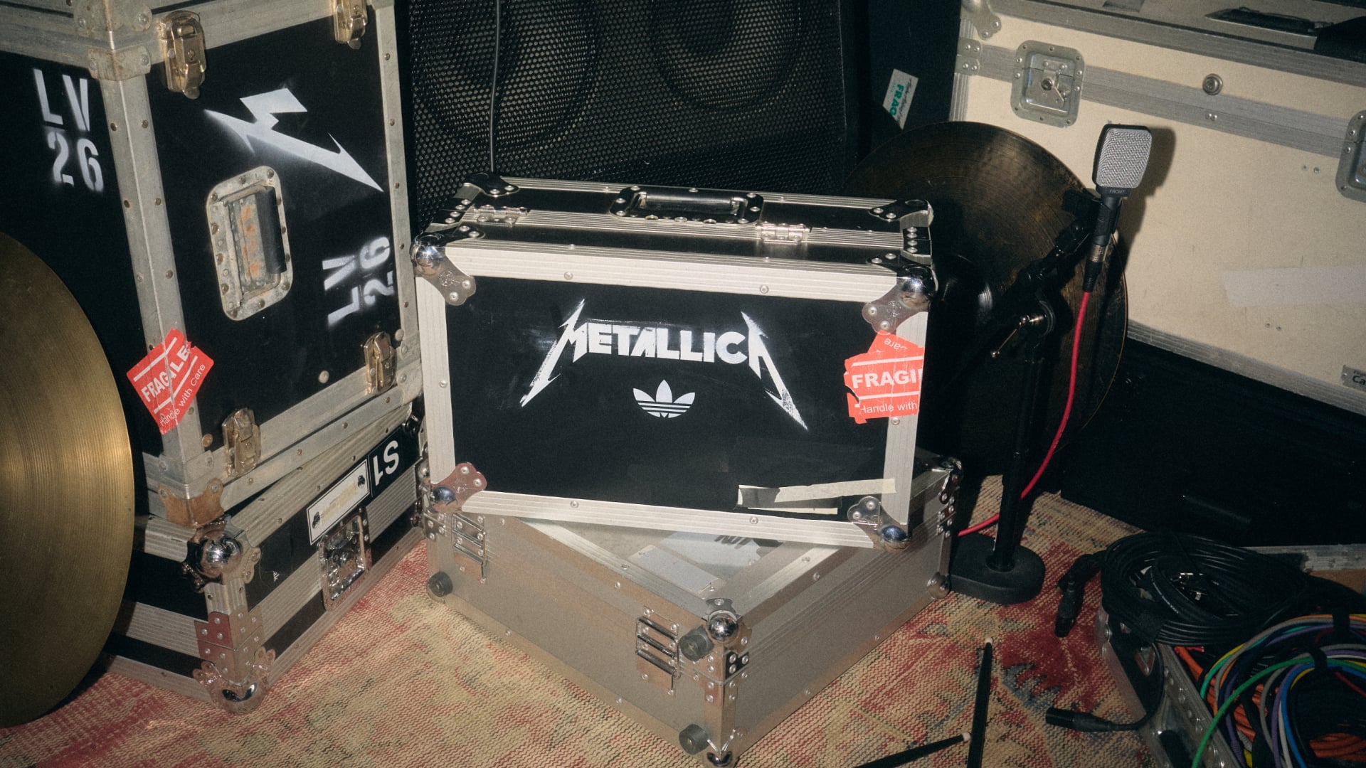 black flight case with white Metallica logo and adidas trefoil, fragile sticker, Life Burns Faster