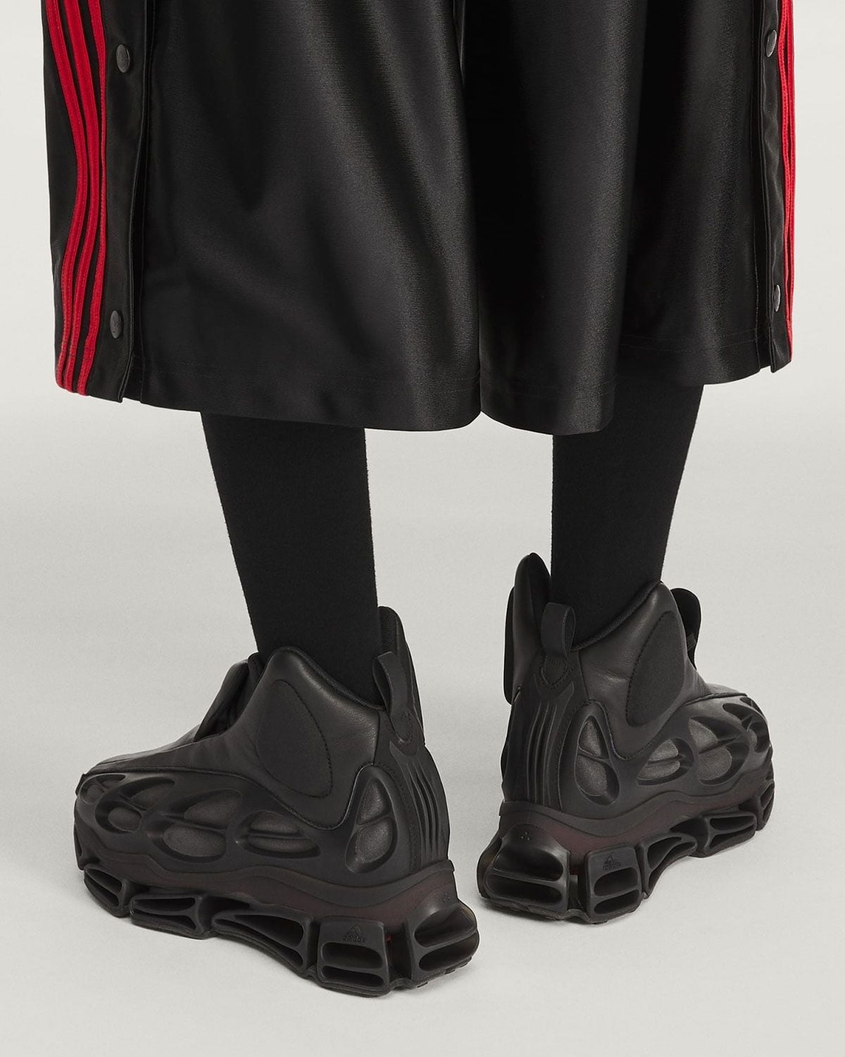 on-foot back view, black leather mid-top boots below black track pants, red stripes, Willy Mega Mid)