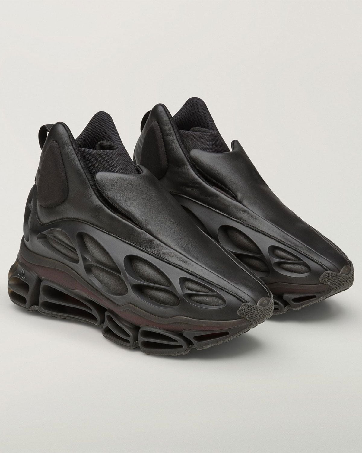 three-quarter view of black leather mid-top pair with cage-lattice midsole, Willy Mega Mid)