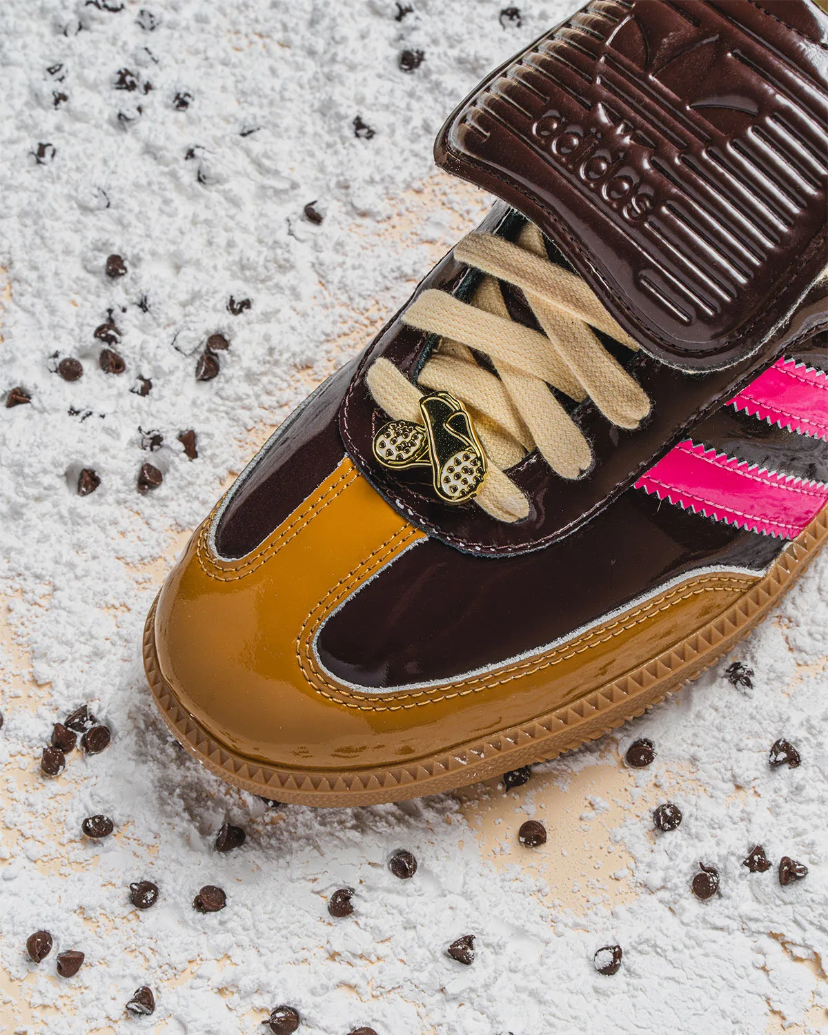 toe close-up on powdered sugar and chocolate chips with gold shoe-shaped lace charm, Cannoli