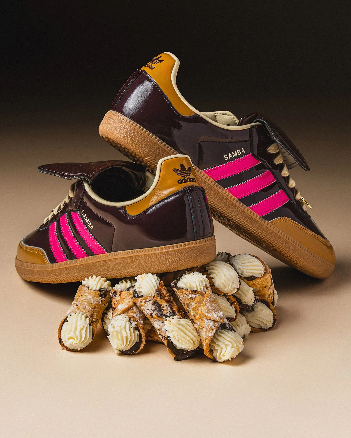 lateral pair propped on a stack of cannoli pastries against dark background, Cannoli
