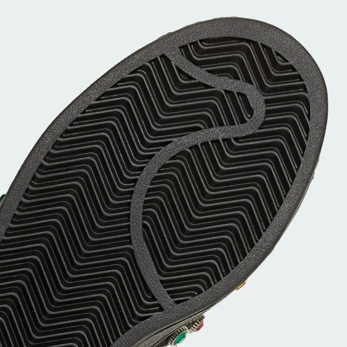 outsole close-up, black herringbone tread pattern with jewels edging into frame, Jewel