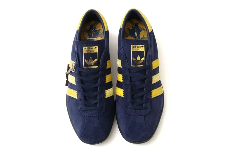 top-down pair, navy suede upper with yellow stripes and gold tongue label, KOYO