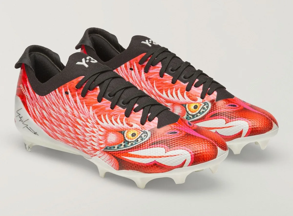 Pair, red bird graphic cleats angled toe-forward on white background, Beast