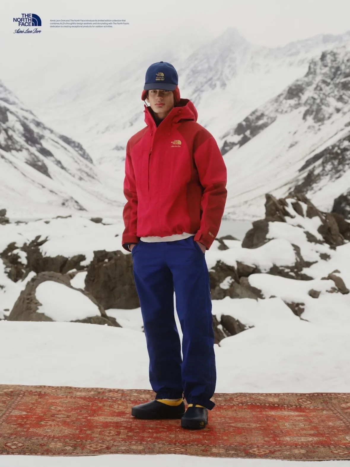 on-foot, red gore-tex jacket, navy logo cap, cobalt blue pants, black clogs, Fall/Winter 2026 Collection