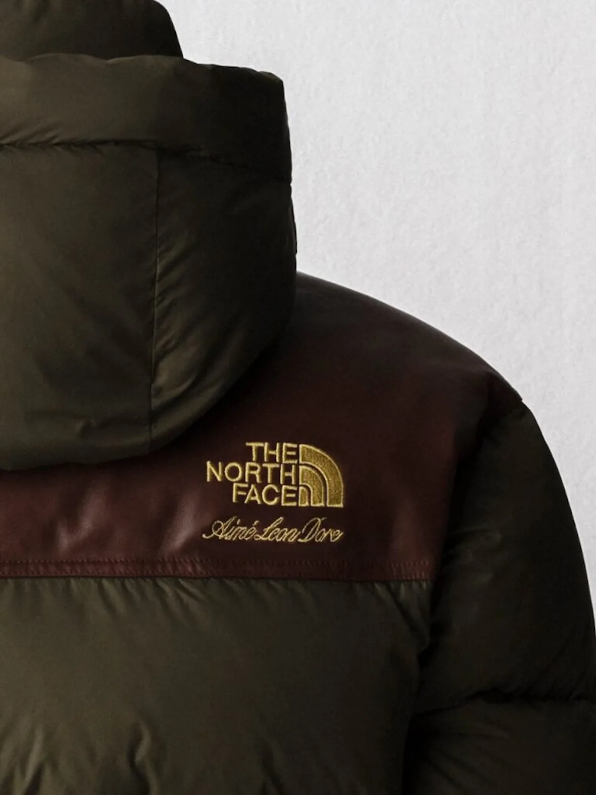 detail, olive puffer shoulder with burgundy yoke, gold embroidered logo, Fall/Winter 2026 Collection