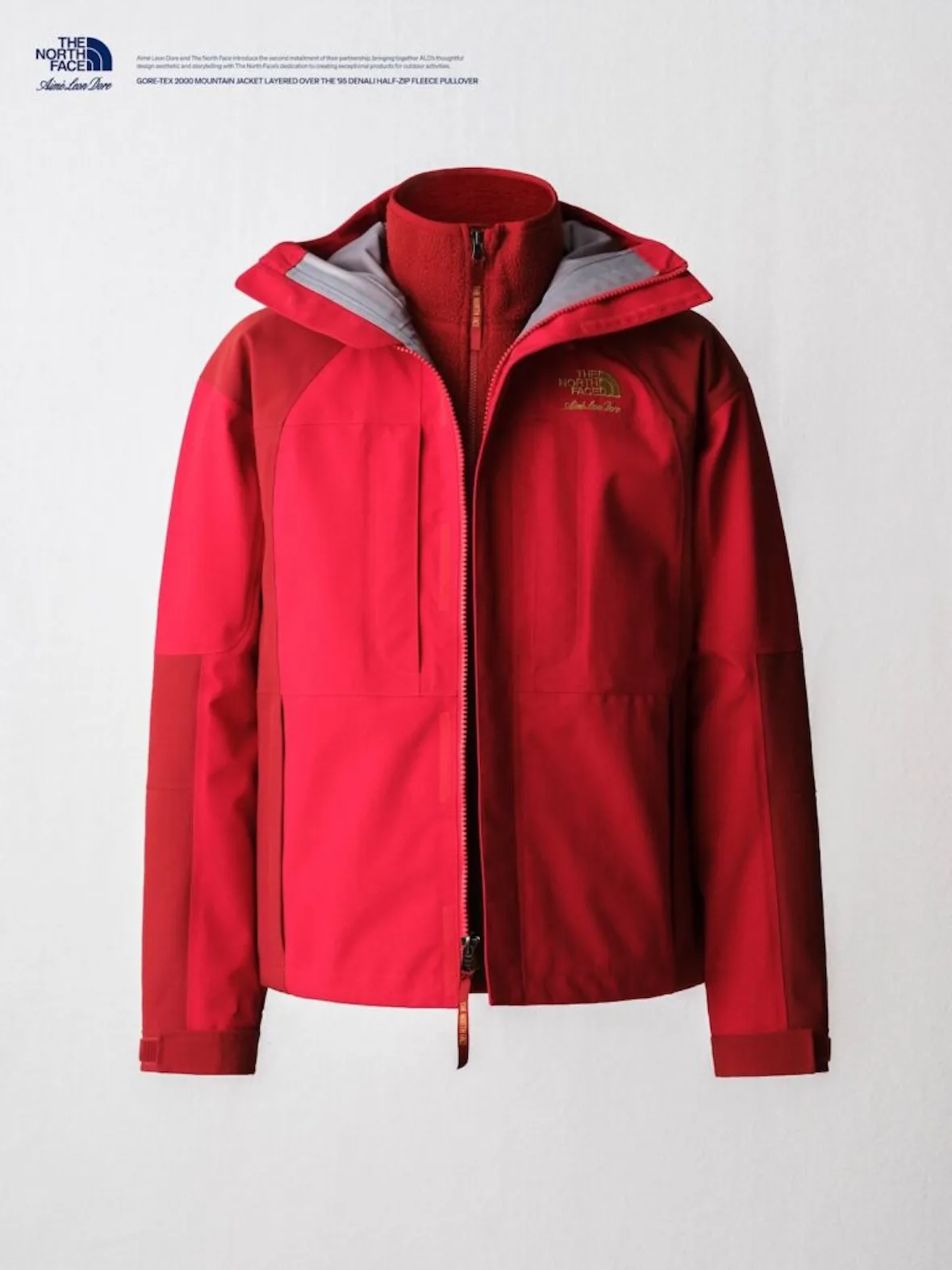 flat-lay, red gore-tex jacket open over burgundy fleece collar, gold logo, Fall/Winter 2026 Collection