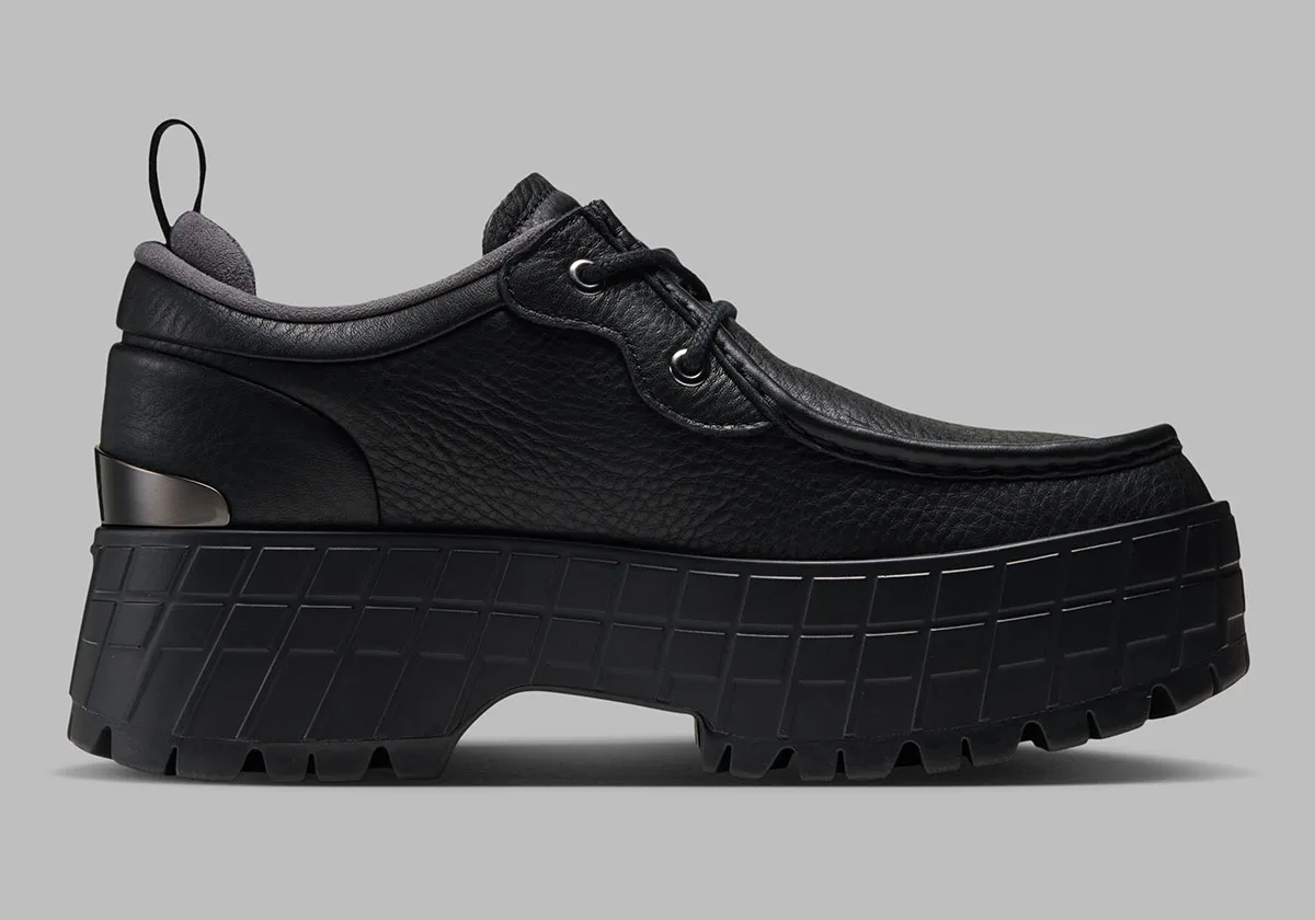 lateral view, black leather upper with grey heel pull tab and lugged sole, Jordan 1 Brooklyn