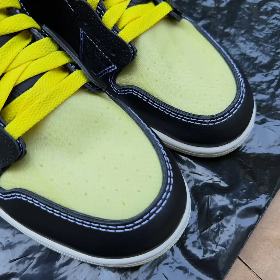 toe box close-up showing pale yellow perforated toe caps and yellow laces, Black/Lightning