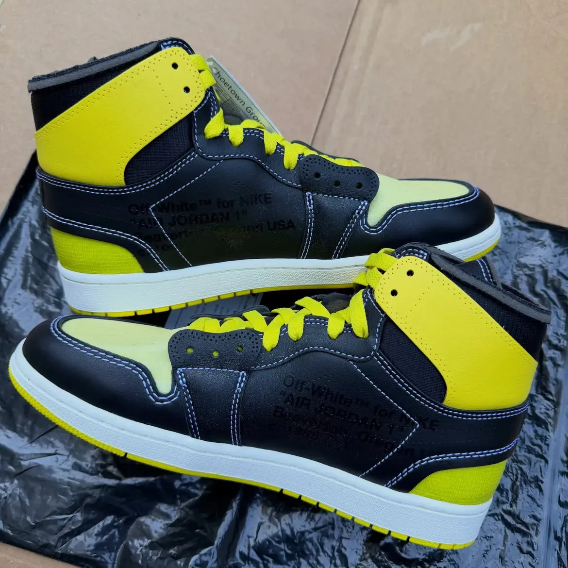 pair medial view with black "Off-White for NIKE Air Jordan 1" text on heel, Black/Lightning