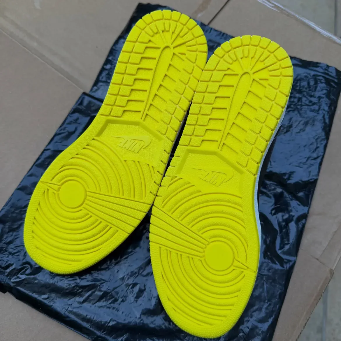 outsole pair view with bright yellow rubber soles and Nike branding, Black/Lightning