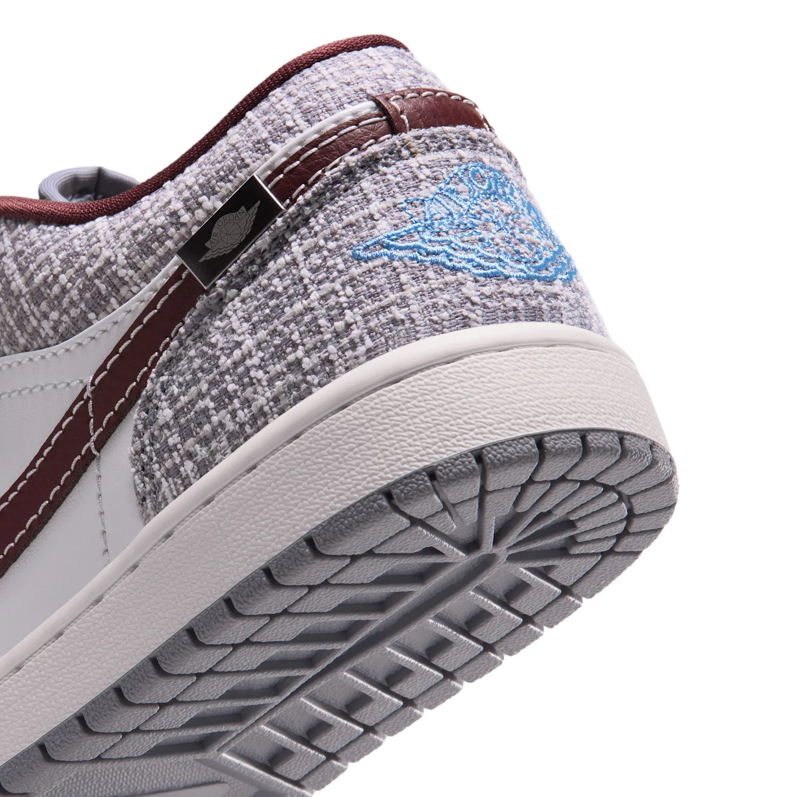 Close-up heel detail, grey bouclé fabric, blue Wings logo, maroon pull tab, Bouclé