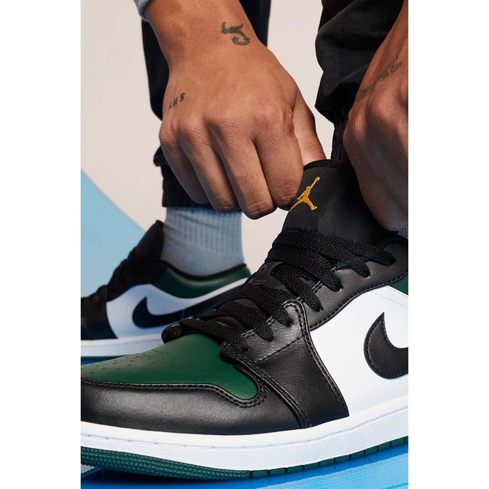 on-foot detail, hand adjusting collar with gold Jumpman logo on ankle, Midnight Spruce
