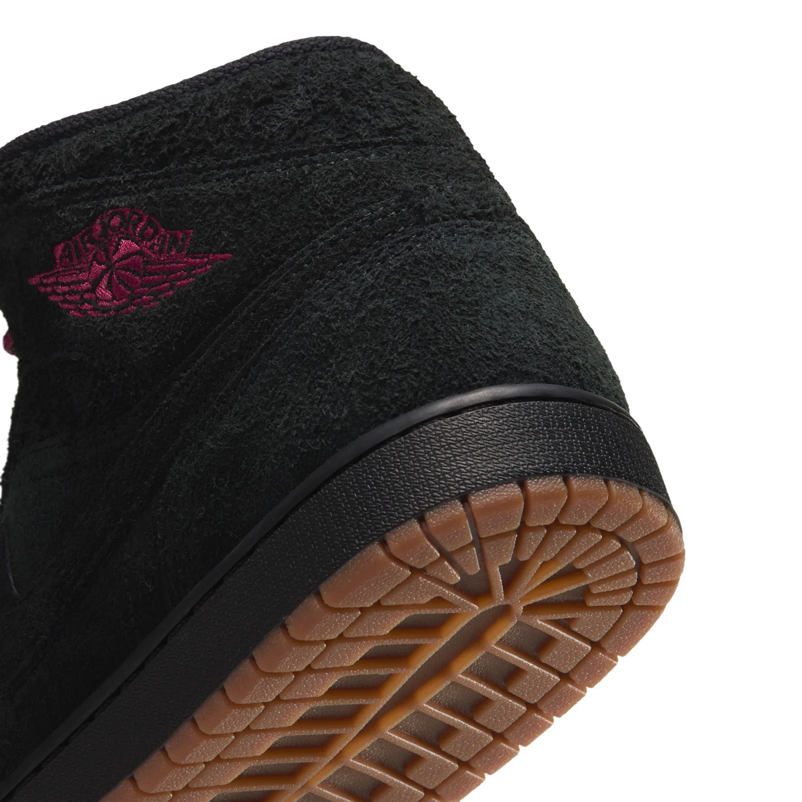 close-up heel detail with burgundy wings logo on black suede, Jordan 1 Mid