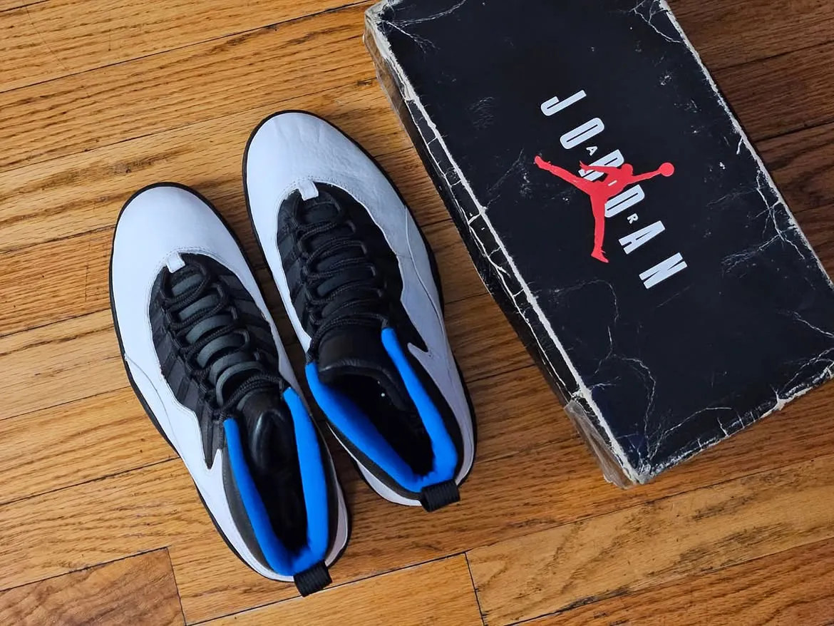 top-down pair beside box with red Jumpman logo and white Jordan lettering, Knicks