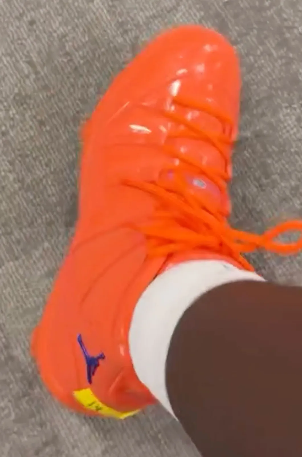 on-foot toe view in orange patent with purple jumpman and yellow tag, Florida Gators