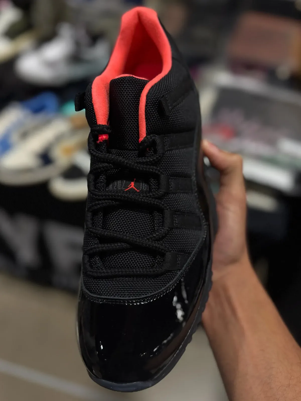 close top-down view of collar and laces, black mesh with coral lining and red Jumpman, Black Infrared