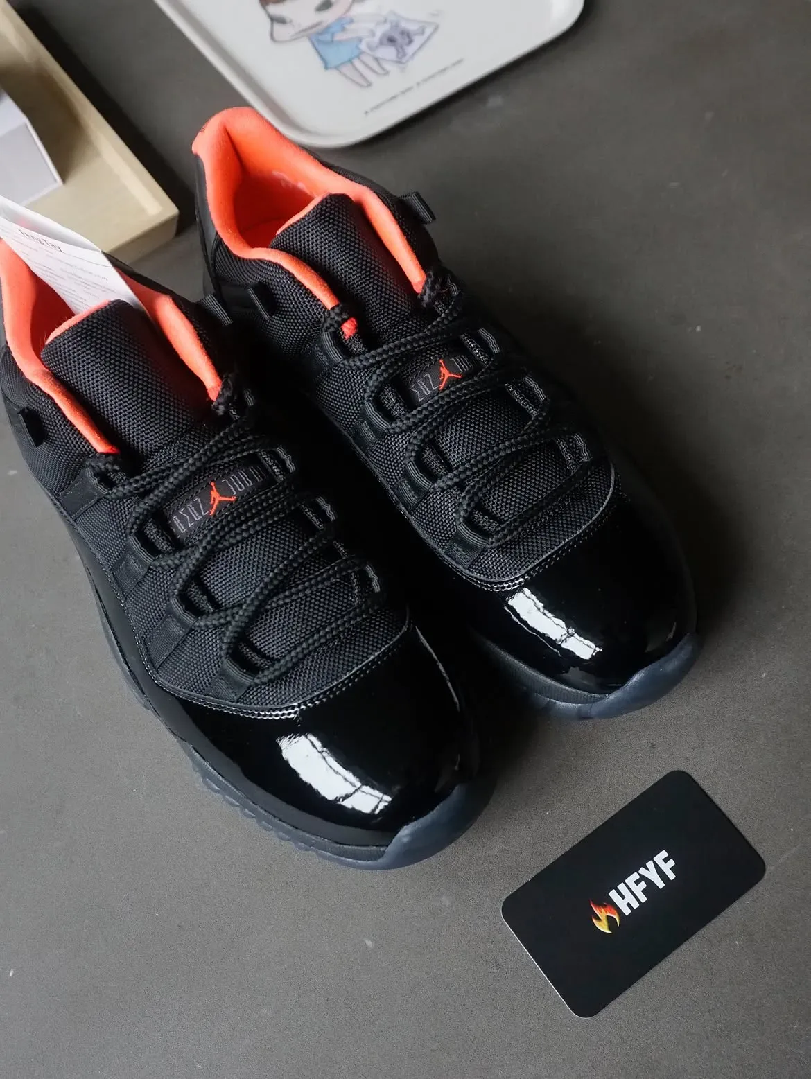 pair top-down on grey surface, black mesh and patent with coral collar lining, tags nearby, Black Infrared