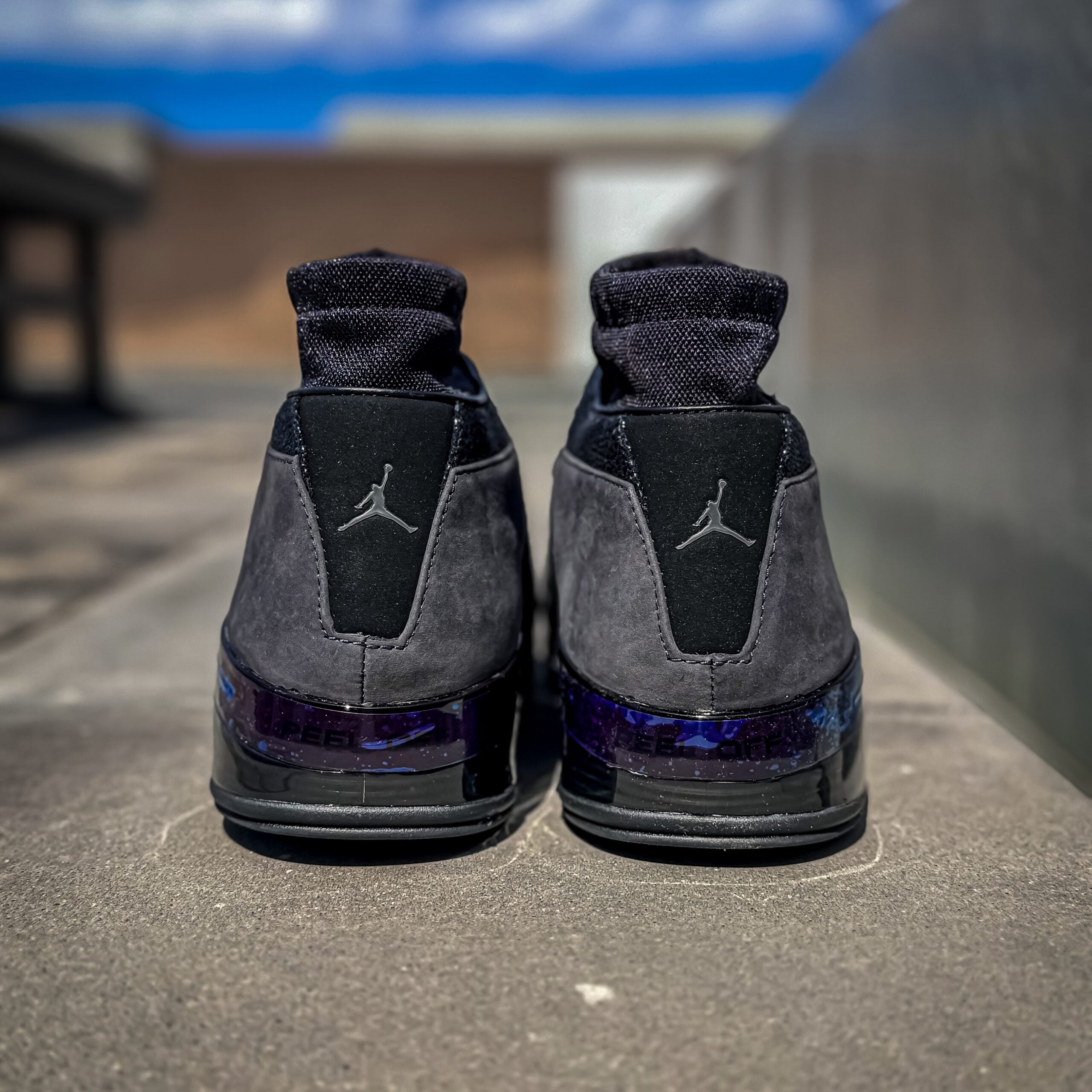 heel view of both shoes, black Jumpman logos and purple speckled patent heel, Black Pack