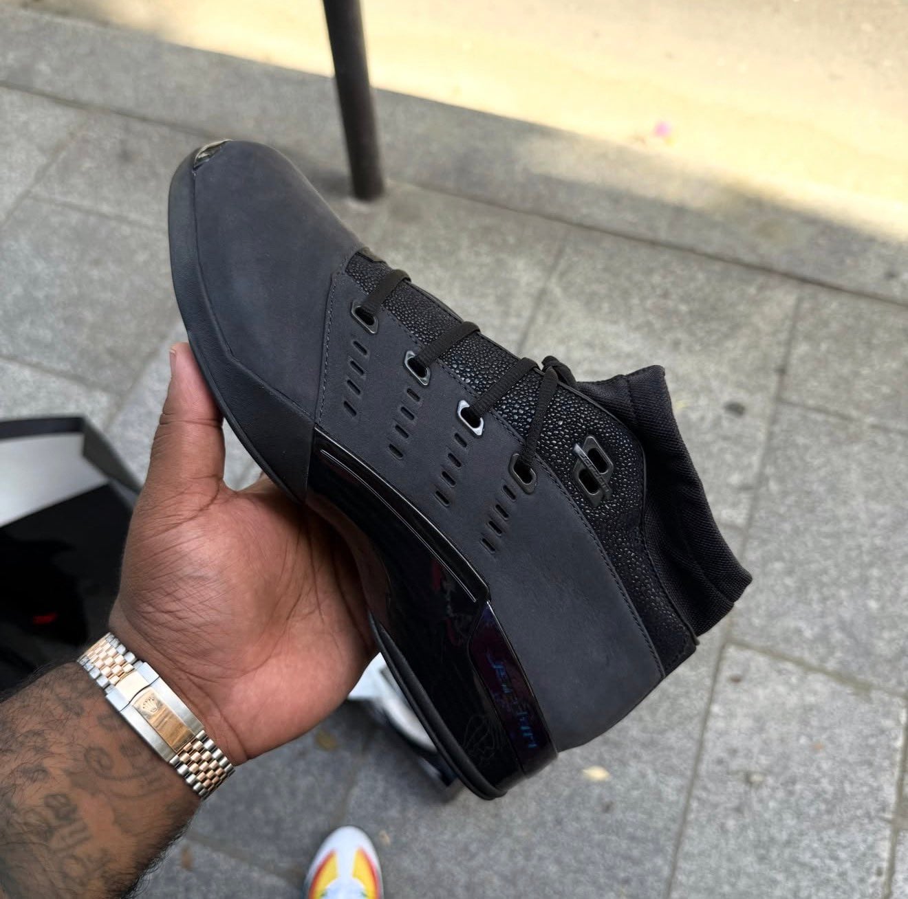 in-hand medial view on sidewalk, grey nubuck with stingray-textured black eyestay, Black Pack