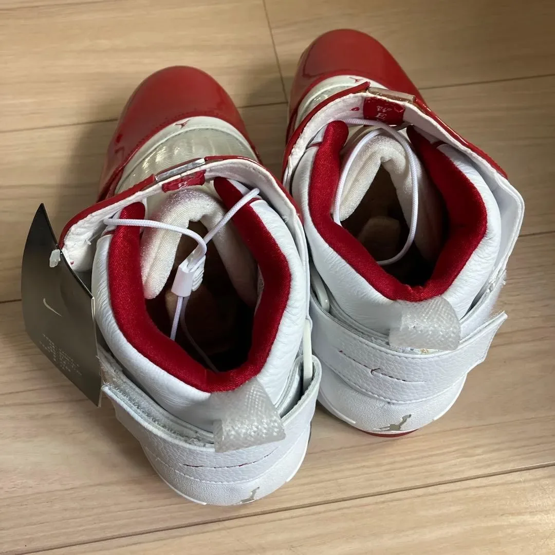 top-down pair on wood floor, red patent toes, white laces, Nike hangtag attached, Midwest