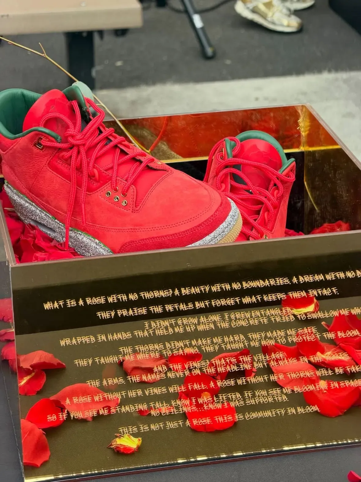 Pair resting in mirrored box with engraved rose poem and scattered petals, Red