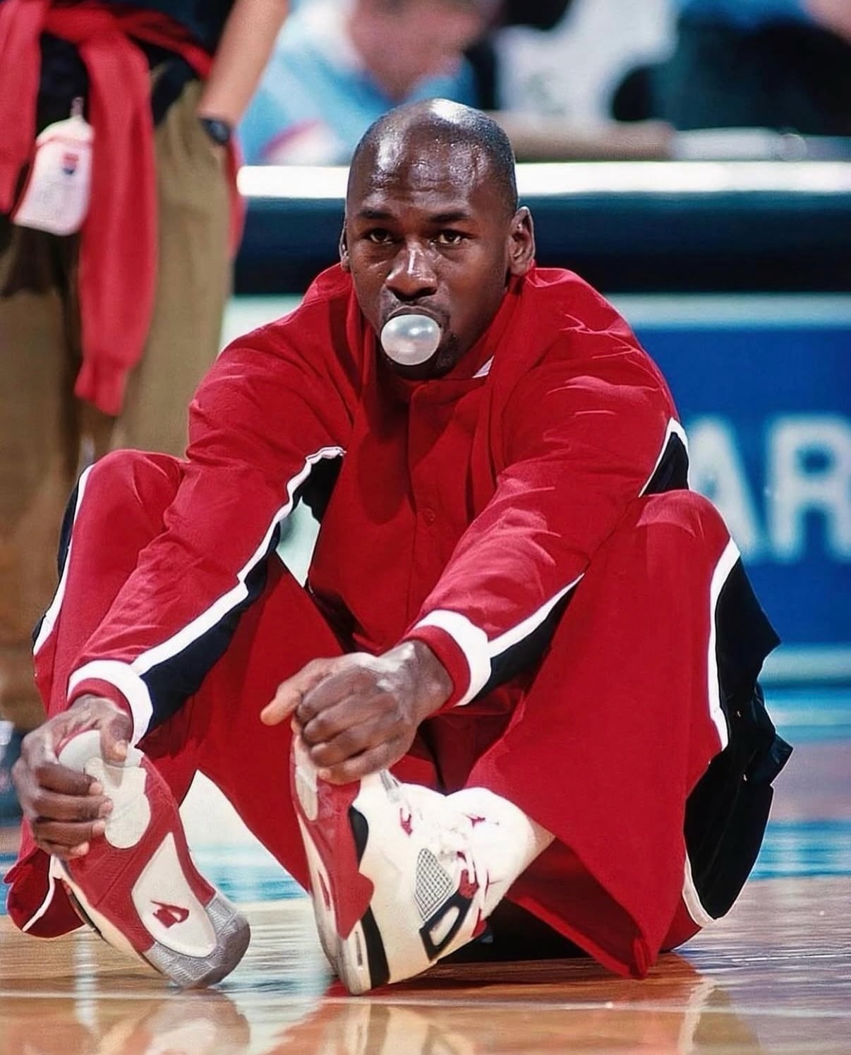on-foot, Michael Jordan ties red-and-white sneakers courtside in red tracksuit, Fire Red