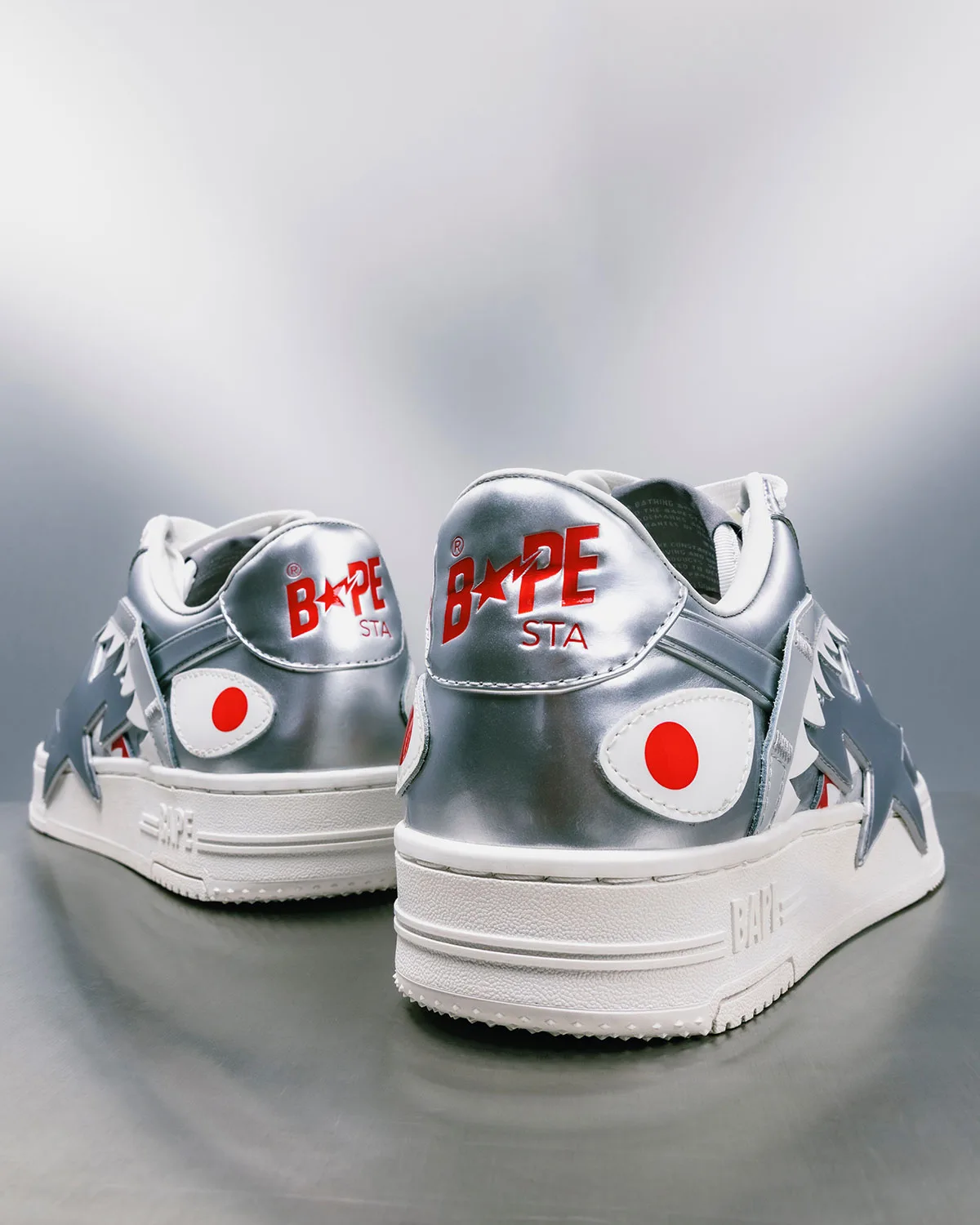 Heel view, silver metallic pair with red circle eyes and ridged white midsole, Future