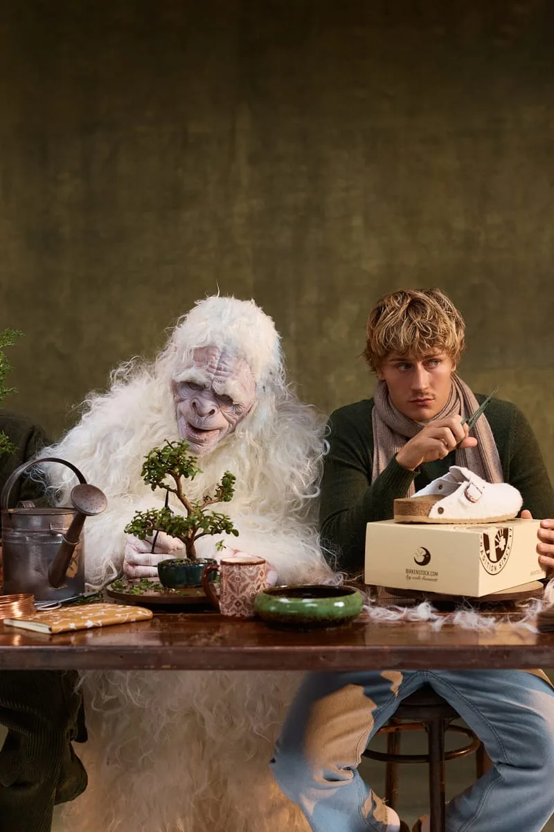 campaign scene, wooly white creature and model at table with shoe on branded box, Wooly Moon Buckle