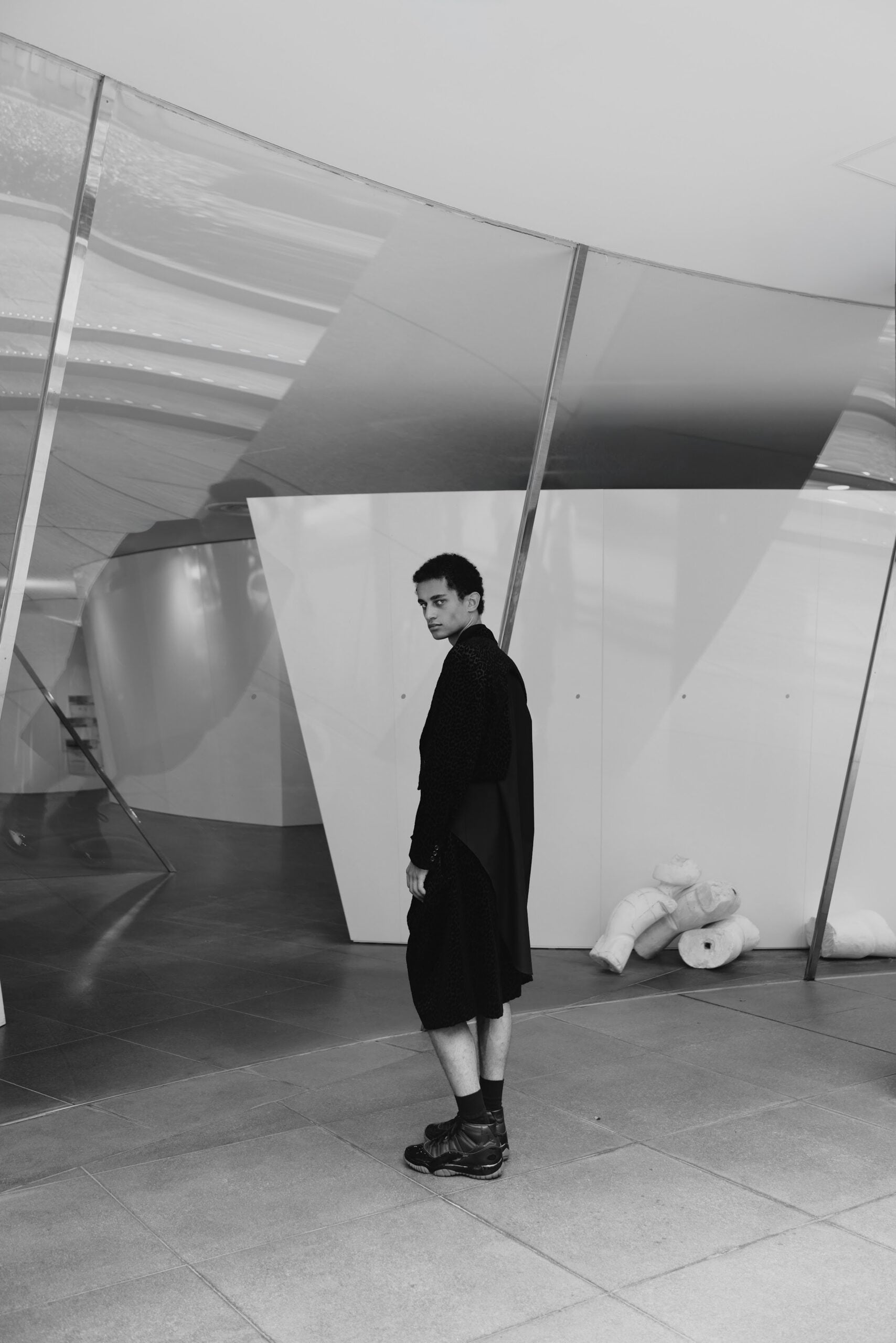 Rear three-quarter view, black leopard-print robe and shorts, black sneakers, Air Jordan 11
