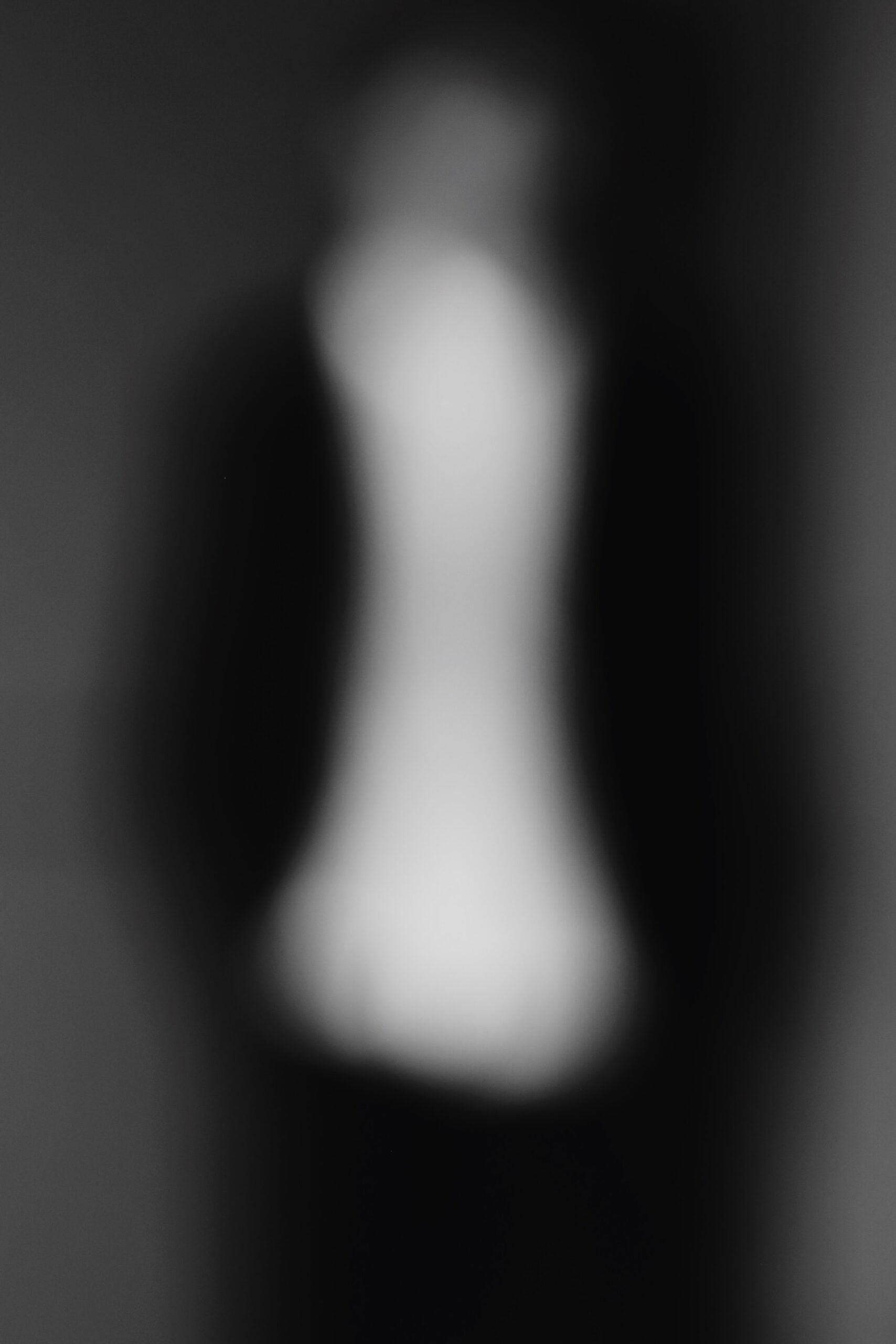 Abstract blurred close-up of a pale sneaker silhouette against black, Air Jordan 11