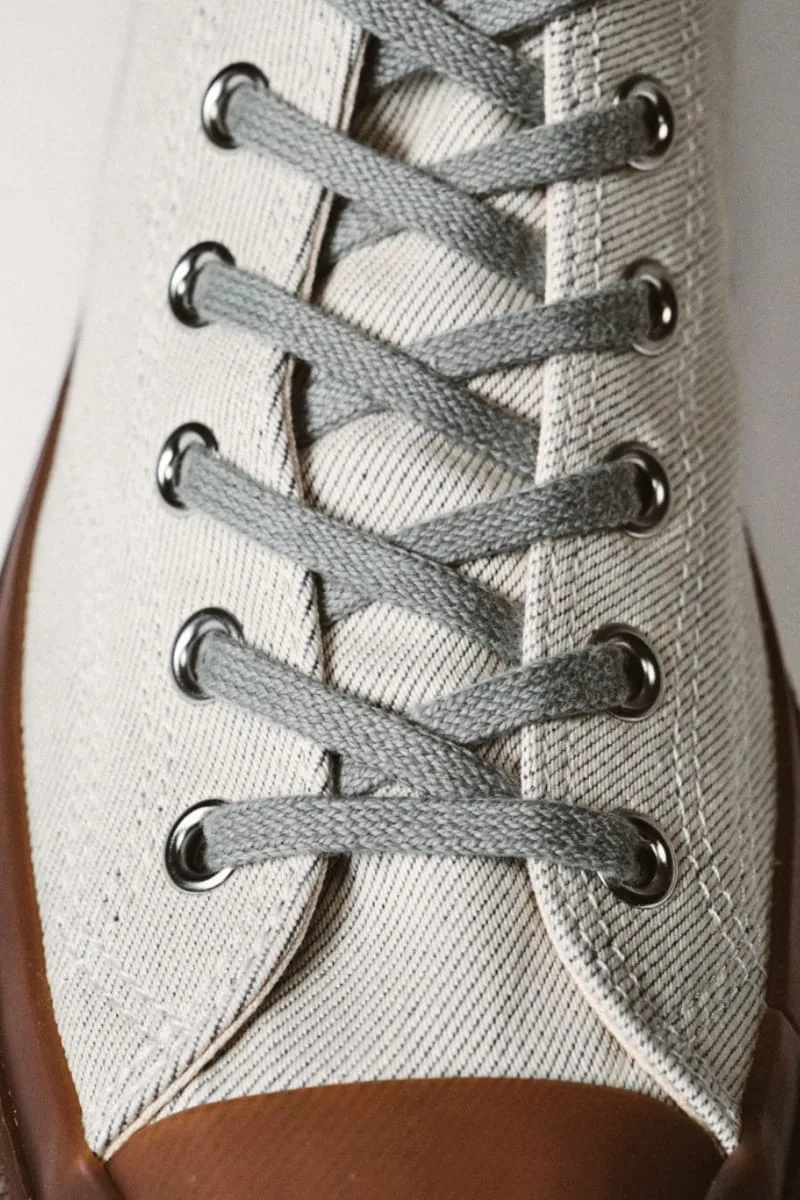 lace detail, grey laces crossed through metal eyelets on cream twill, Natural