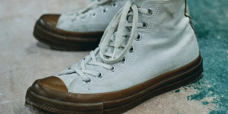 on-foot lateral view, weathered cream canvas high-top with brown toe cap and sole, Natural