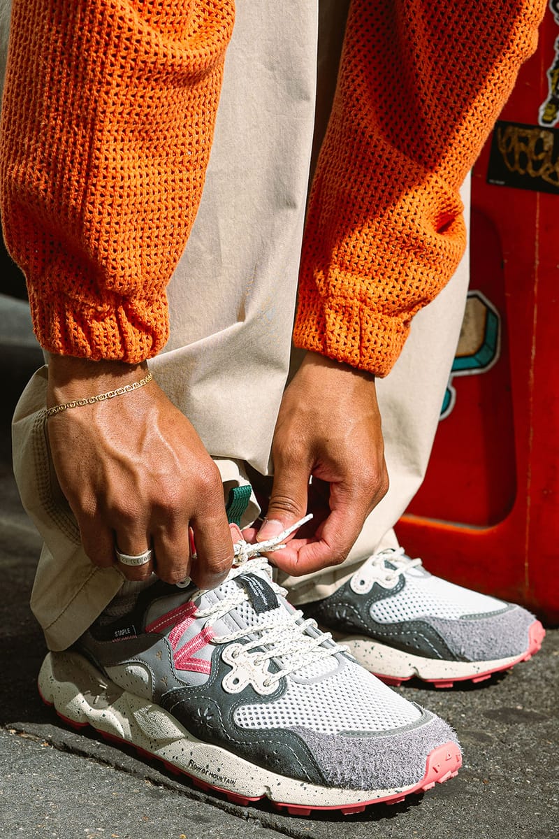 on-foot detail, hands tying cream laces, orange sweater, red backdrop, Staple Yamano 3
