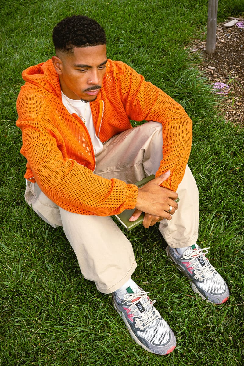 on-foot top-down, seated on grass in orange hoodie holding green notebook, Staple Yamano 3