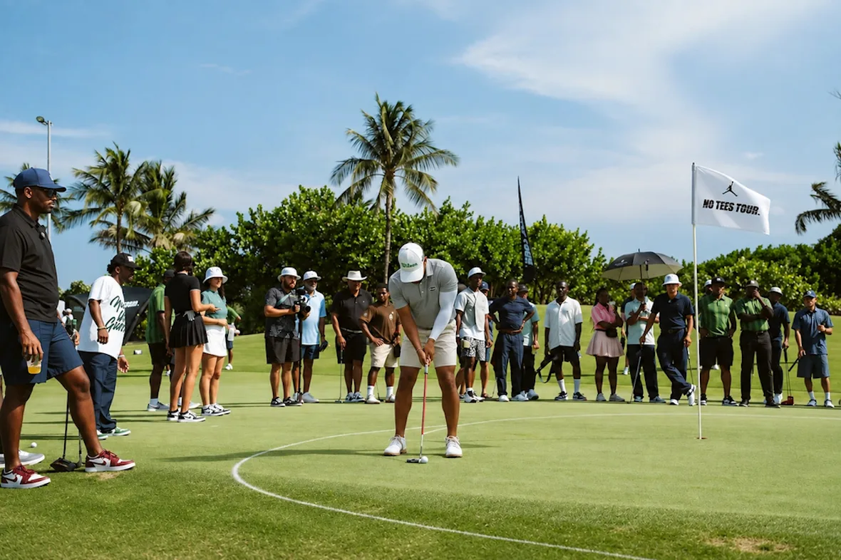 golfer putting on green as crowd watches beside white flag reading 'no tees tour', investment, no product)