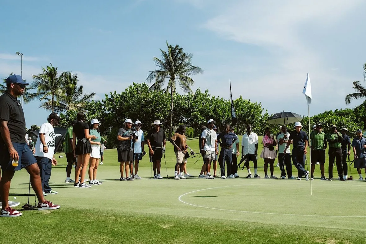 crowd of onlookers lining a putting green with palm trees and white flag, investment, no product)