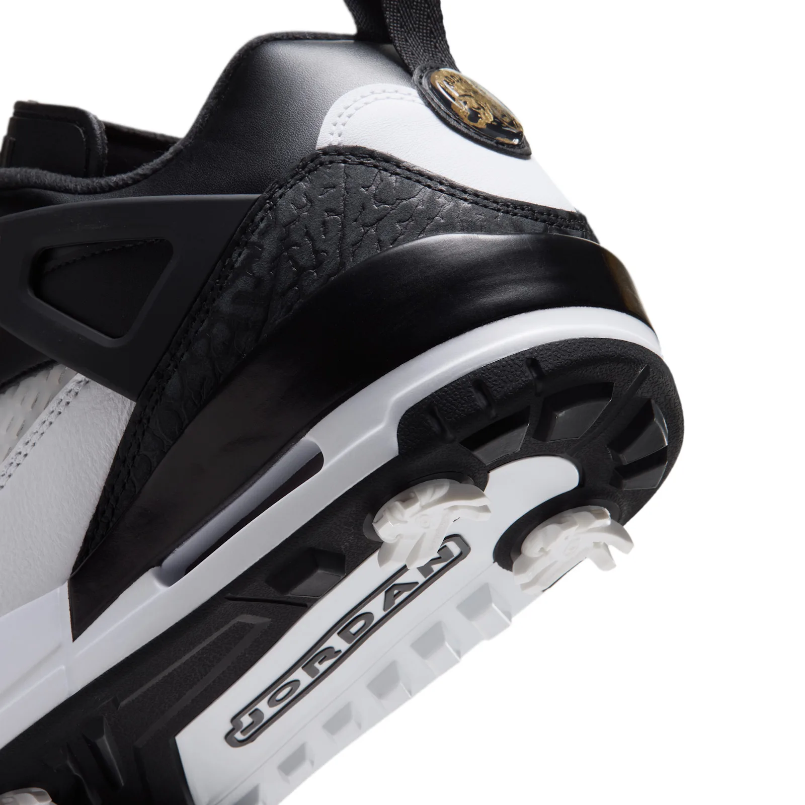 heel close-up, black leather and white panel with gold circular medallion, DMP