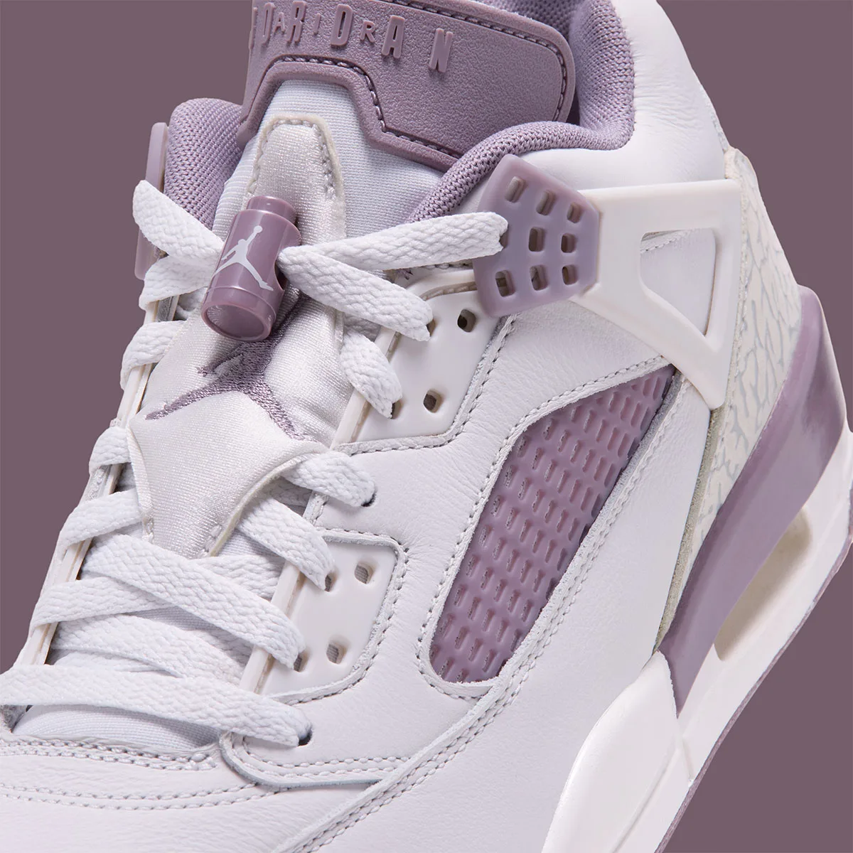 Toe detail close-up showing lace lock, Jumpman charm and mesh panel, Swan