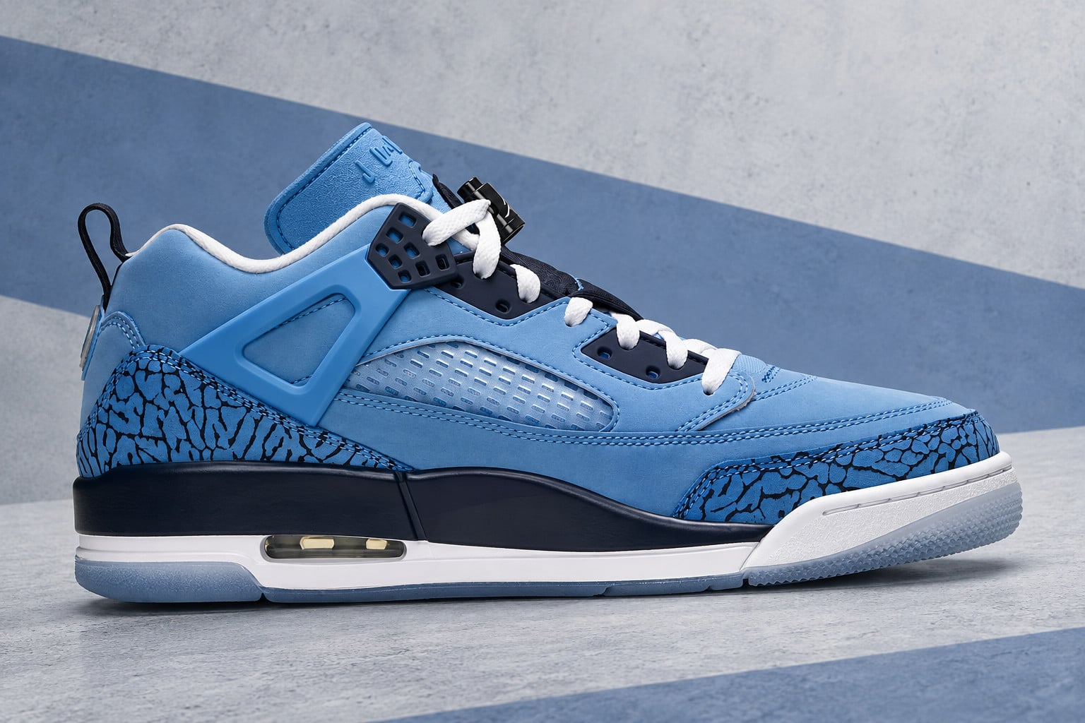 lateral view, blue nubuck with navy elephant print and white midsole on concrete backdrop, Jordan Spiz’ike Low “UNC”
