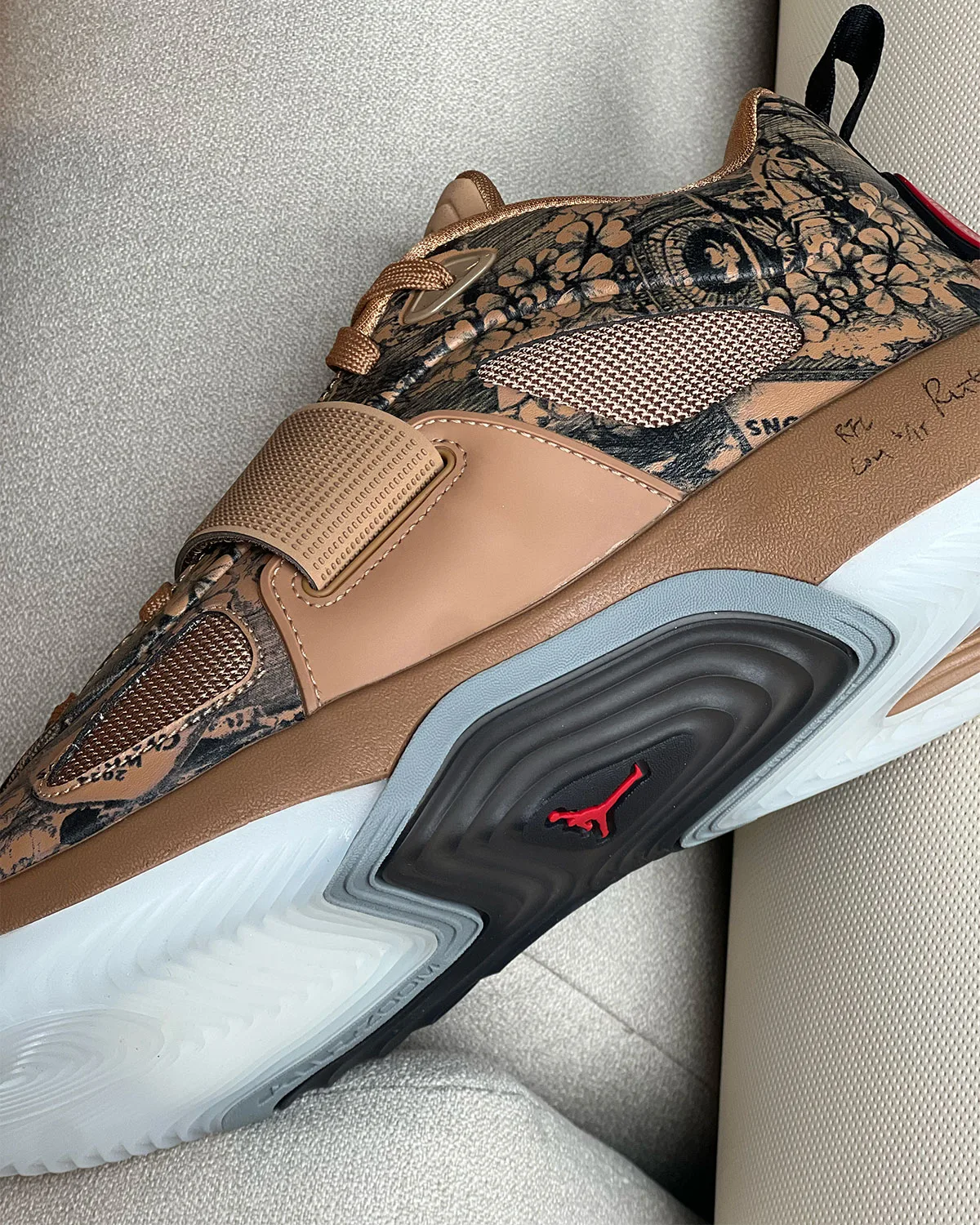 Medial detail, tan floral print upper with red Jumpman on black midsole, Jordan Tatum 5