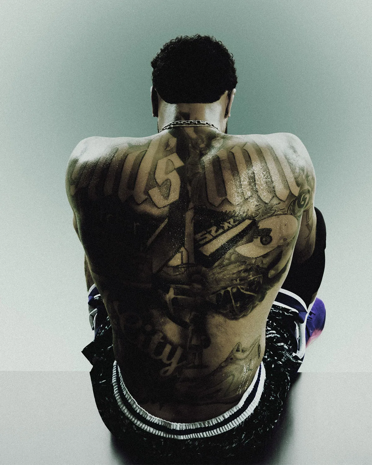 On-foot lifestyle, tattooed man's back with purple shoe on foot, Jordan Tatum 5