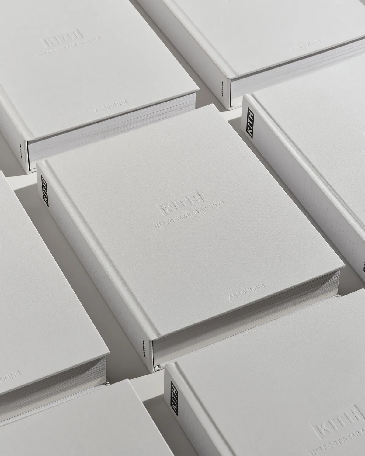 close-up angled view of grey book covers with embossed kith logo, The Footwear Archive