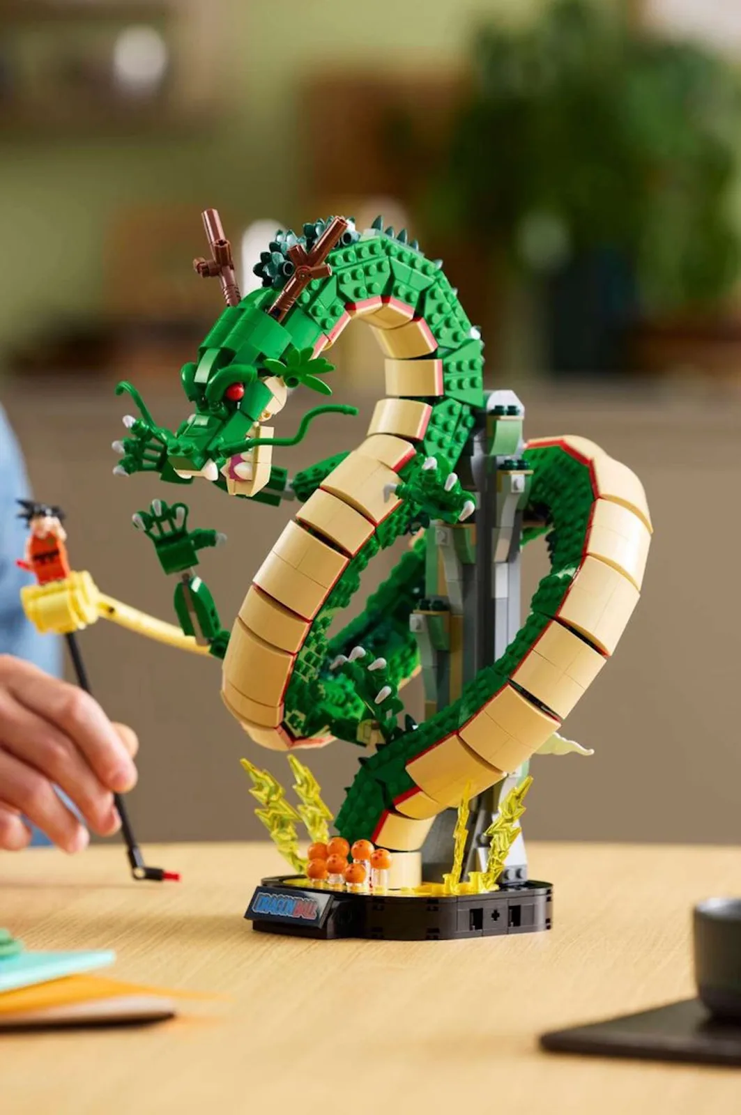on-foot lifestyle shot of dragon build on wooden table beside teacups, Shenron & Goku