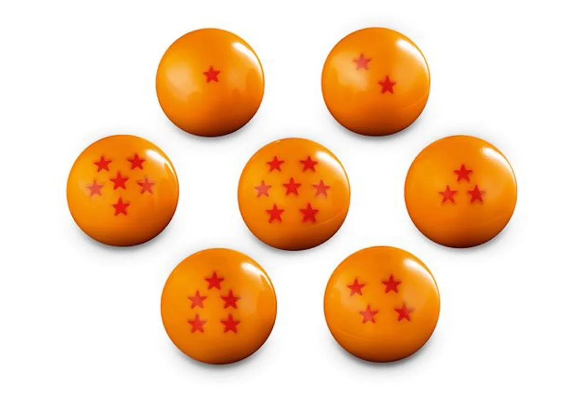 detail of seven orange stud-shooter dragon ball spheres with red stars, Shenron & Goku
